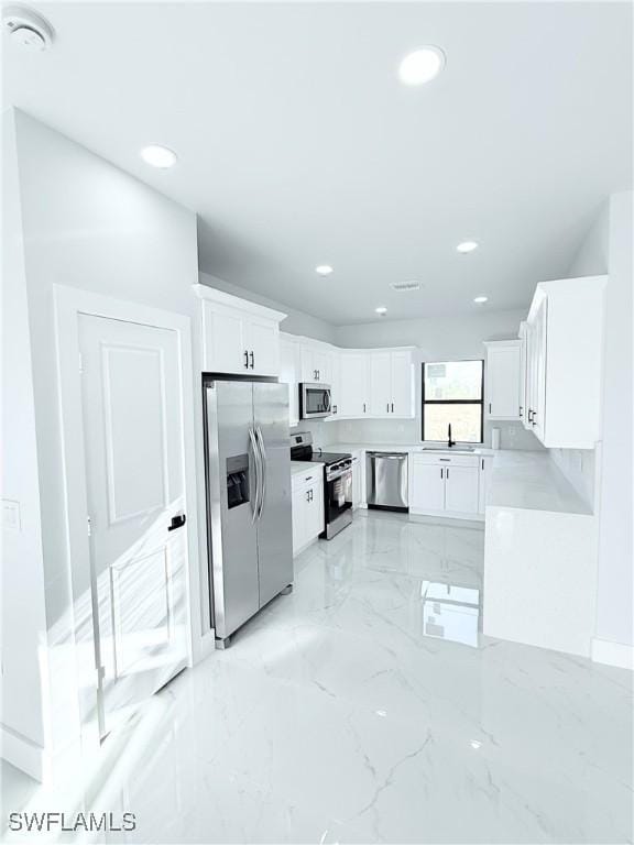 kitchen featuring white cabinets, stainless steel appliances, and sink