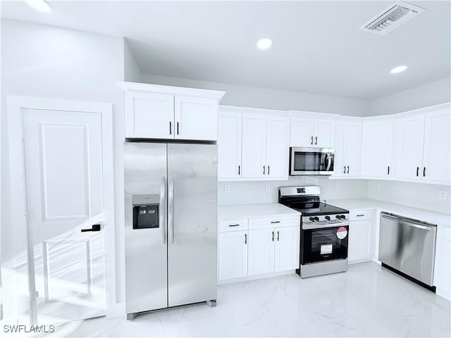 kitchen featuring stainless steel appliances and white cabinetry