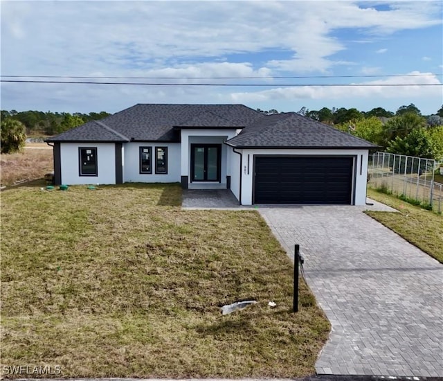 view of front of house featuring a garage, a front yard, and french doors