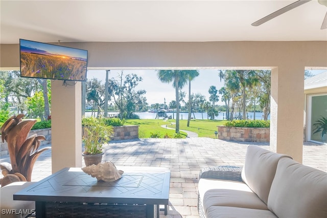 view of patio / terrace featuring a water view and ceiling fan