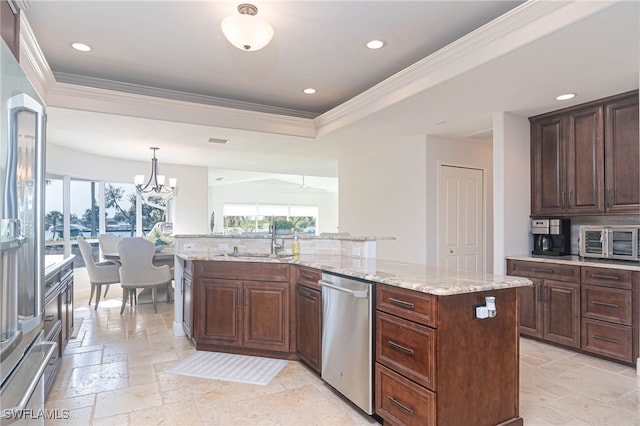 kitchen with a center island with sink, sink, appliances with stainless steel finishes, decorative light fixtures, and dark brown cabinetry