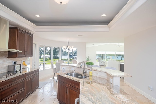 kitchen featuring light stone counters, sink, a wealth of natural light, and a chandelier