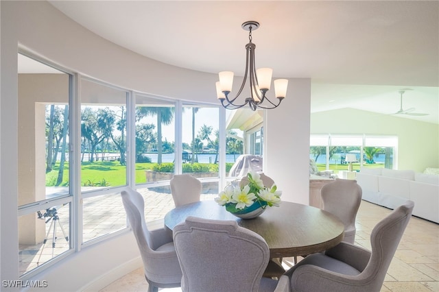 dining area with plenty of natural light, ceiling fan with notable chandelier, and vaulted ceiling