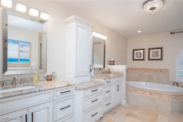 bathroom with vanity and tiled tub