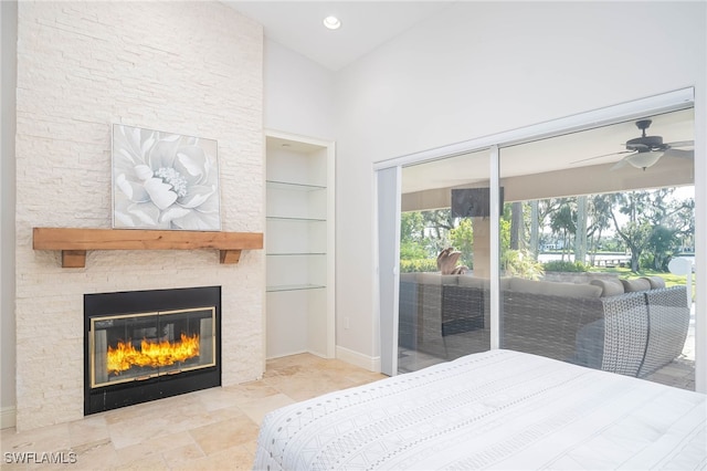 bedroom featuring high vaulted ceiling, access to outside, a stone fireplace, and ceiling fan