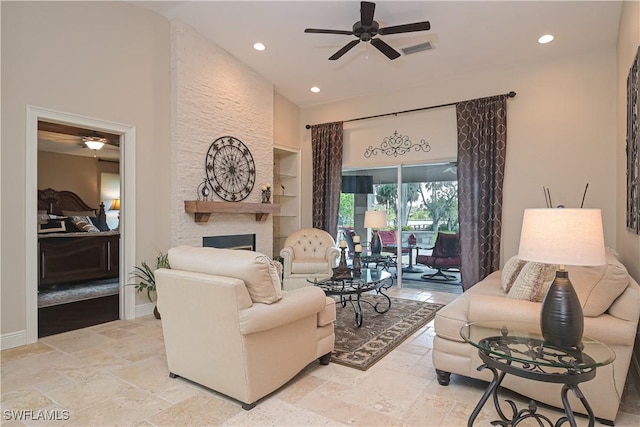 living room with ceiling fan, a stone fireplace, and built in features