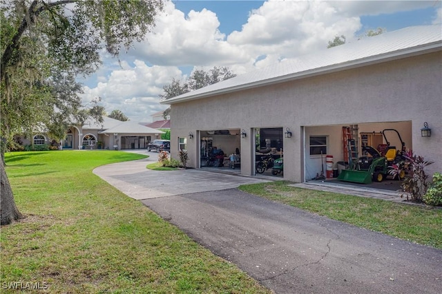 view of side of property featuring a garage and a lawn