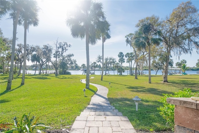 surrounding community featuring a lawn and a water view