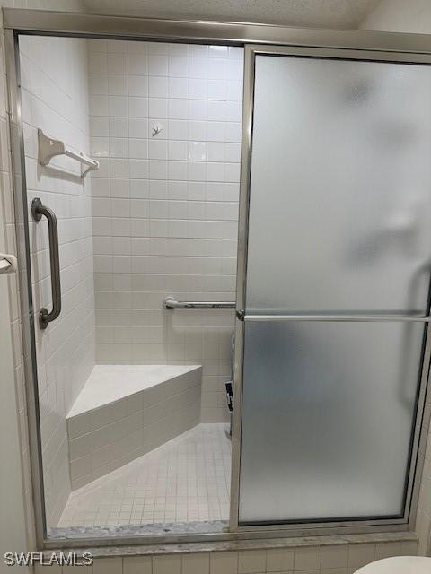 full bathroom featuring a shower stall and toilet