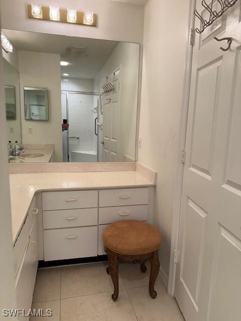 full bathroom featuring walk in shower, vanity, and tile patterned floors