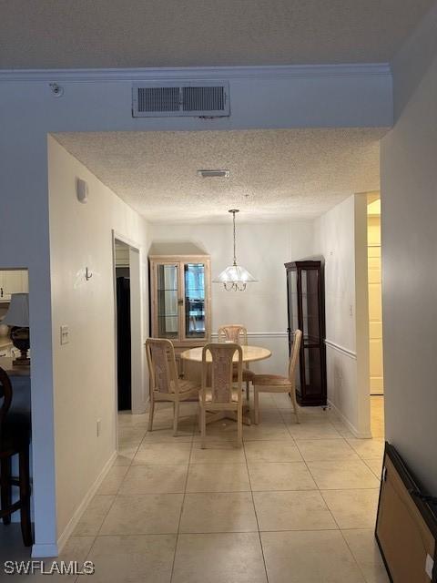 dining room featuring baseboards, visible vents, an inviting chandelier, a textured ceiling, and light tile patterned flooring