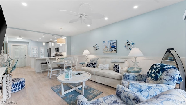 living room with ceiling fan and light wood-type flooring