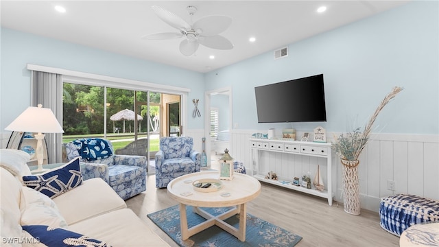 living room with ceiling fan and light hardwood / wood-style flooring