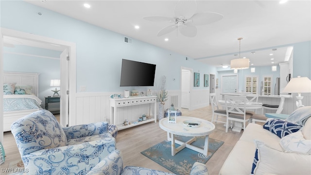 living room featuring light hardwood / wood-style floors and ceiling fan