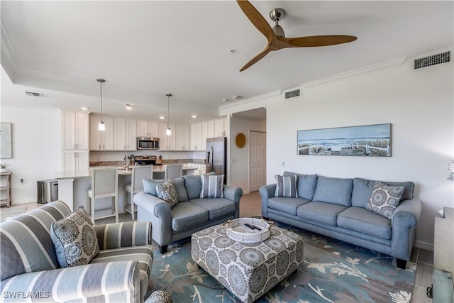 living room with ceiling fan and crown molding