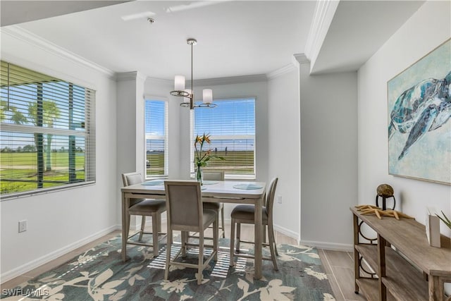 dining area with plenty of natural light, hardwood / wood-style floors, a notable chandelier, and ornamental molding