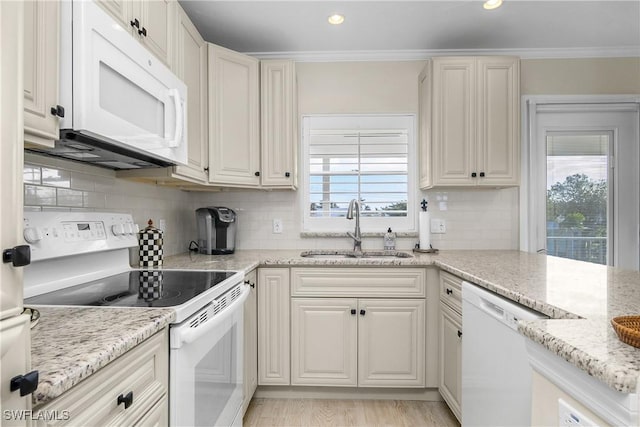 kitchen with light stone countertops, sink, white appliances, decorative backsplash, and ornamental molding