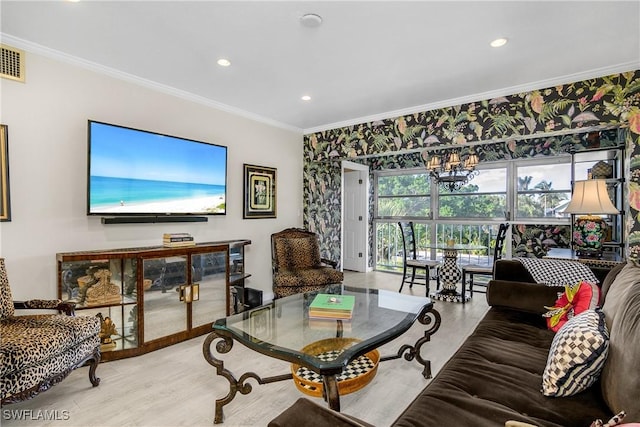 living room with light wood-type flooring, crown molding, and a chandelier