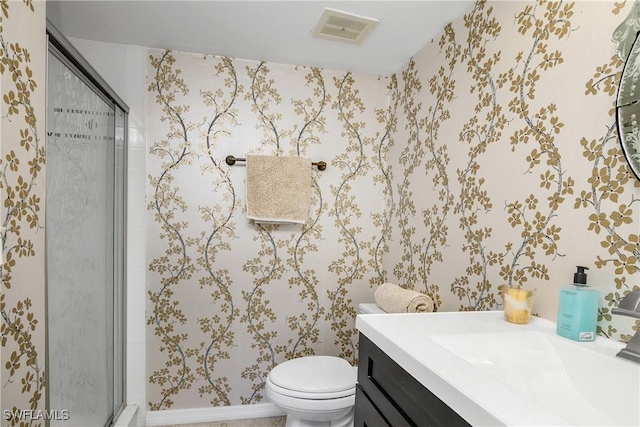 bathroom with a shower with door, vanity, and toilet