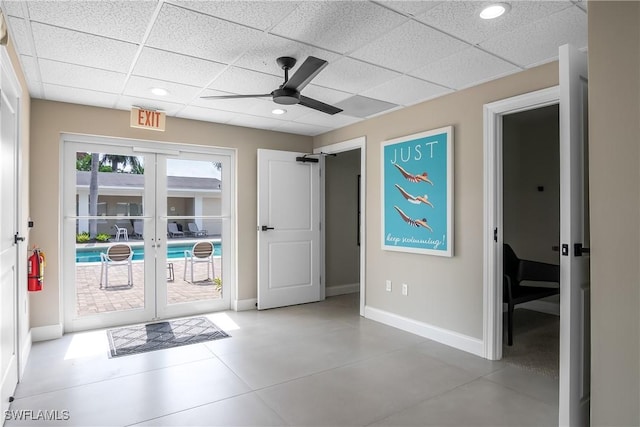 doorway with a paneled ceiling, ceiling fan, and french doors