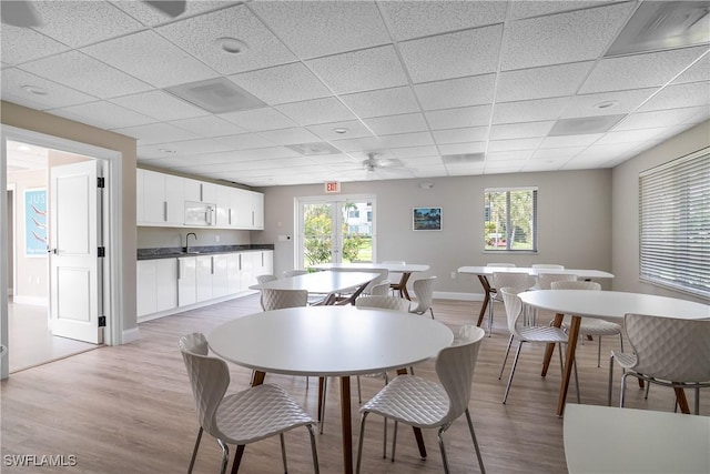 dining room featuring a drop ceiling, light hardwood / wood-style flooring, ceiling fan, and sink