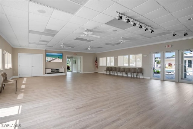 unfurnished living room with a paneled ceiling, light wood-type flooring, and ornamental molding