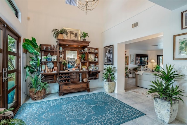 interior space with a towering ceiling and light tile patterned flooring