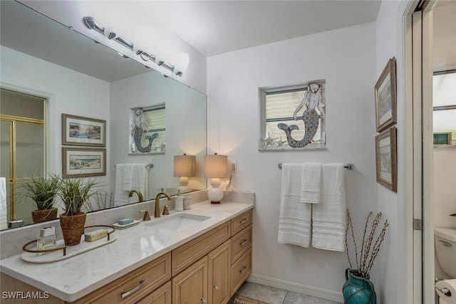 bathroom featuring tile patterned floors, vanity, toilet, and an enclosed shower