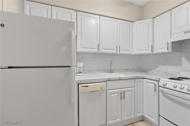 kitchen with white cabinets, light stone counters, white appliances, and sink