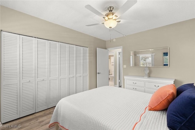 bedroom with a closet, light hardwood / wood-style flooring, and ceiling fan