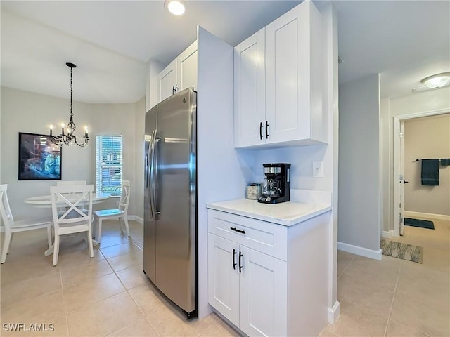 kitchen with an inviting chandelier, white cabinets, light tile patterned floors, decorative light fixtures, and stainless steel fridge with ice dispenser