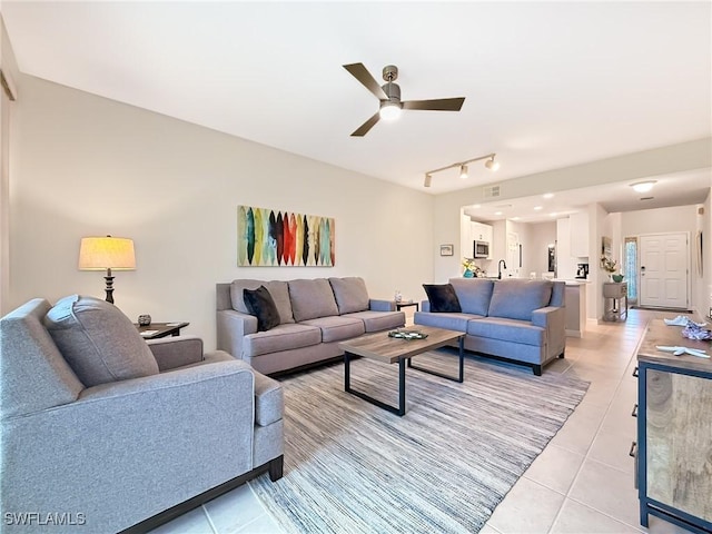 living room with ceiling fan, light tile patterned floors, and track lighting