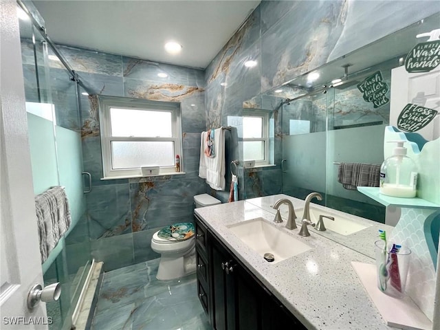 bathroom with plenty of natural light, tile walls, an enclosed shower, and vanity