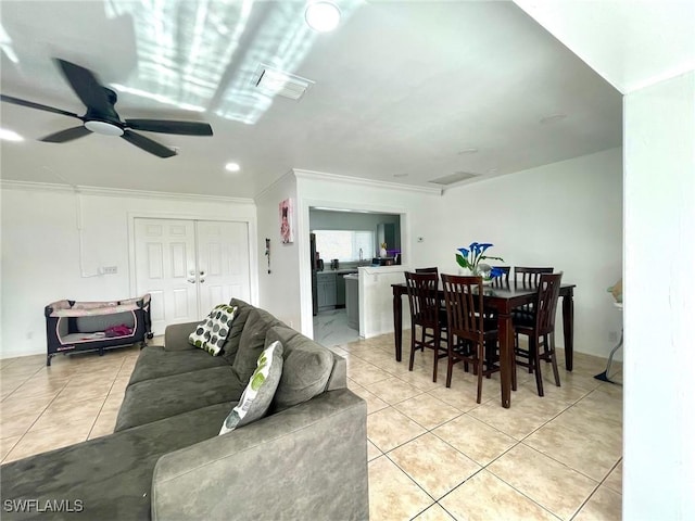 living room with ceiling fan, light tile patterned floors, and crown molding