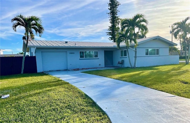 single story home with a garage and a front lawn