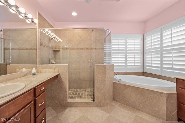 bathroom featuring tile patterned flooring, vanity, and shower with separate bathtub