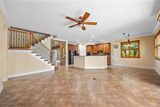 unfurnished living room featuring ceiling fan with notable chandelier and ornamental molding