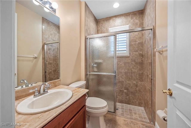 bathroom featuring tile patterned floors, vanity, toilet, and walk in shower