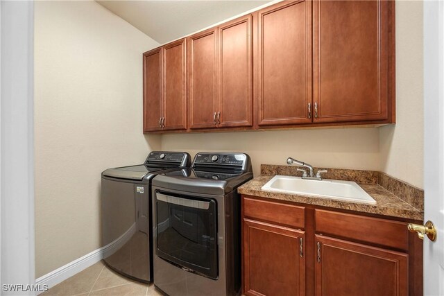 clothes washing area featuring cabinets, light tile patterned floors, separate washer and dryer, and sink