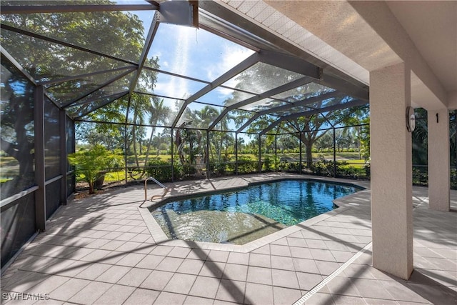 view of pool with glass enclosure and a patio area