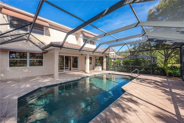 view of swimming pool with glass enclosure and a patio