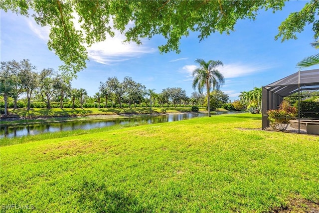 view of yard with a water view and a lanai