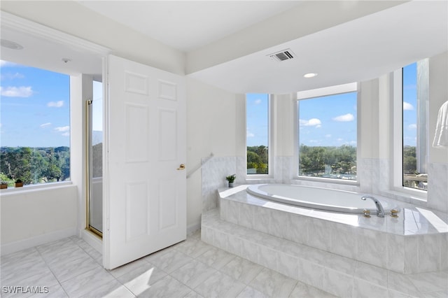 bathroom featuring shower with separate bathtub and a wealth of natural light