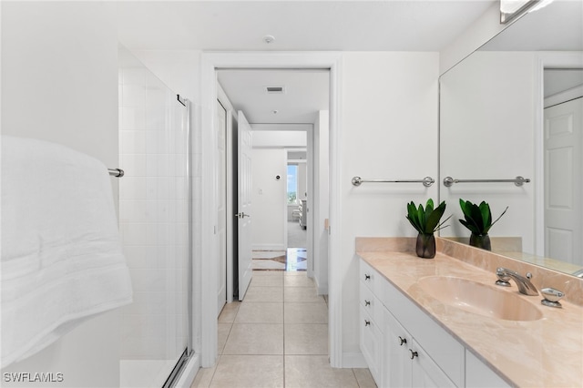 bathroom featuring tile patterned floors, vanity, and a shower with shower door