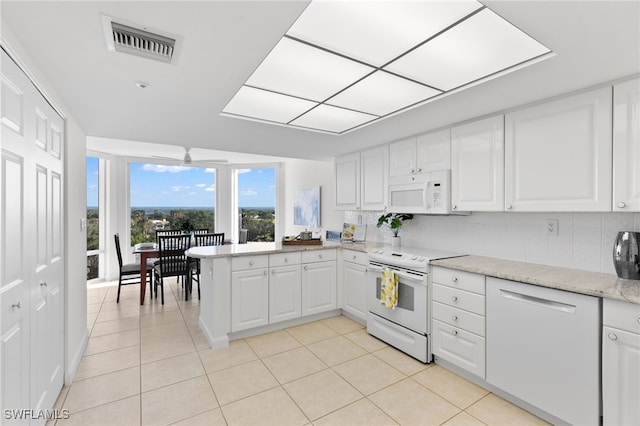 kitchen featuring white cabinetry, light tile patterned flooring, white appliances, and backsplash