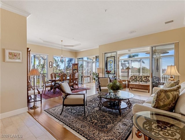 living room featuring light wood-type flooring, crown molding, and a wealth of natural light