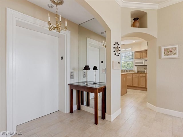 hallway with light hardwood / wood-style floors, an inviting chandelier, ornamental molding, and sink