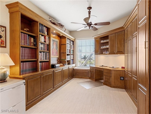 unfurnished office featuring ceiling fan and light colored carpet