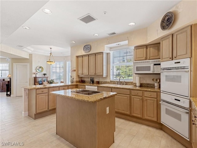 kitchen featuring a center island, kitchen peninsula, sink, and a wealth of natural light