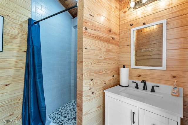 bathroom featuring curtained shower, wooden walls, and vanity